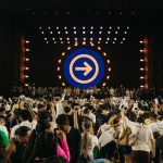 Público acompanha uma apresentação musical diante de um palco iluminado durante um festival no Pará.