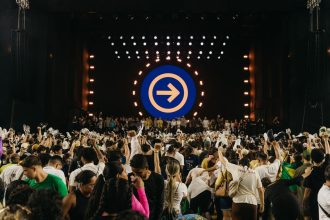 Público acompanha uma apresentação musical diante de um palco iluminado durante um festival no Pará.