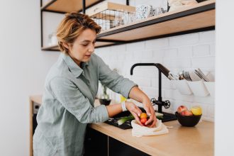 Mulher prepara vegetais frescos em uma cozinha.