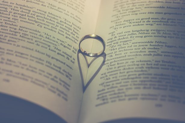 Livro aberto com alianças e elementos em formato de coração, em uma composição sobre amor e casamento
